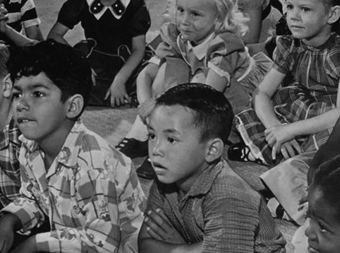 Historical photo of young students of different races, ethnicities.