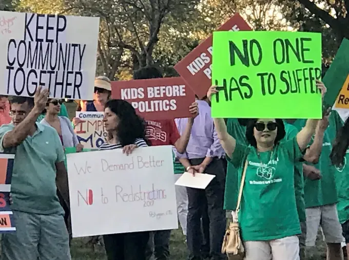 Protestors hold signs.