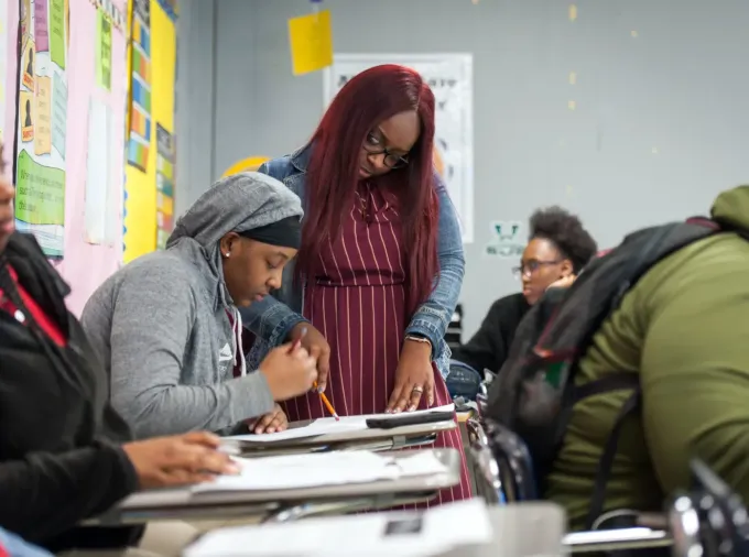 Black English teacher working with Black students.